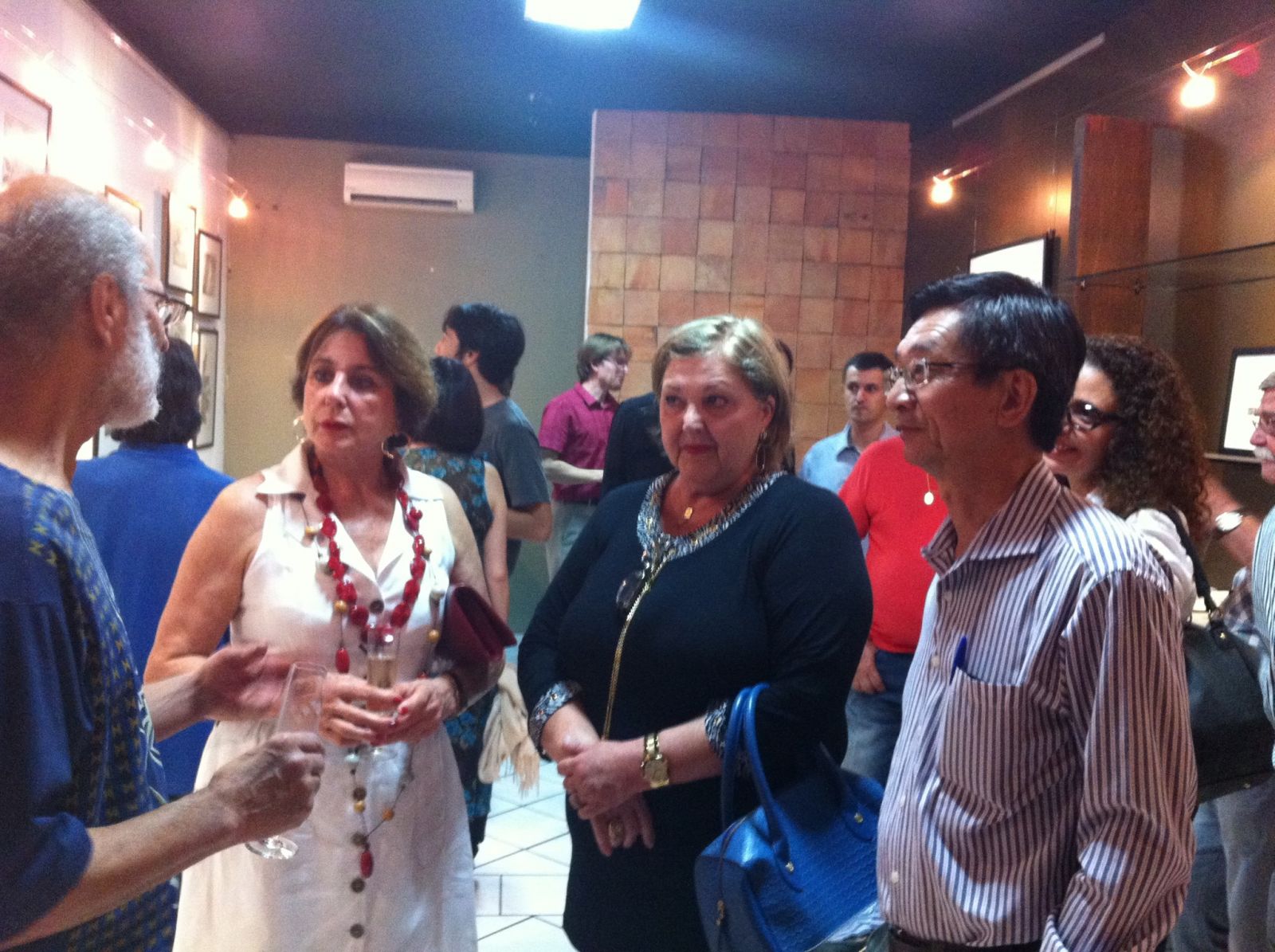 Tai (à direita) recebe convidados/as na abertura da exposição de xilogravuras. O evento foi prestigiado pela professor Saida Cunha